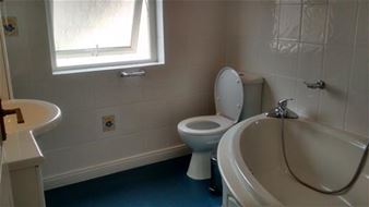 photo of main bathroom showing corner bath, toilet etc.